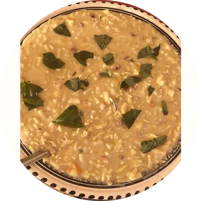 Pasta e patate con provola e foglie di basilico, in un piatto di ceramica