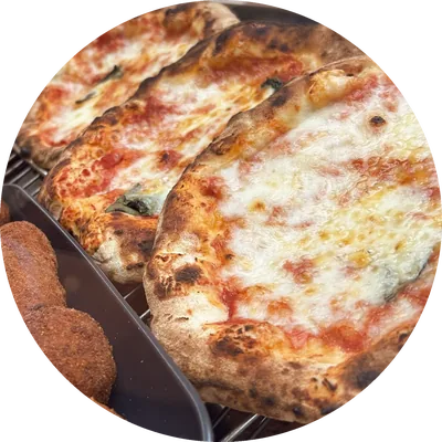 Pizze al pomodoro e mozzarella appena sfornate, in fila nella vetrina